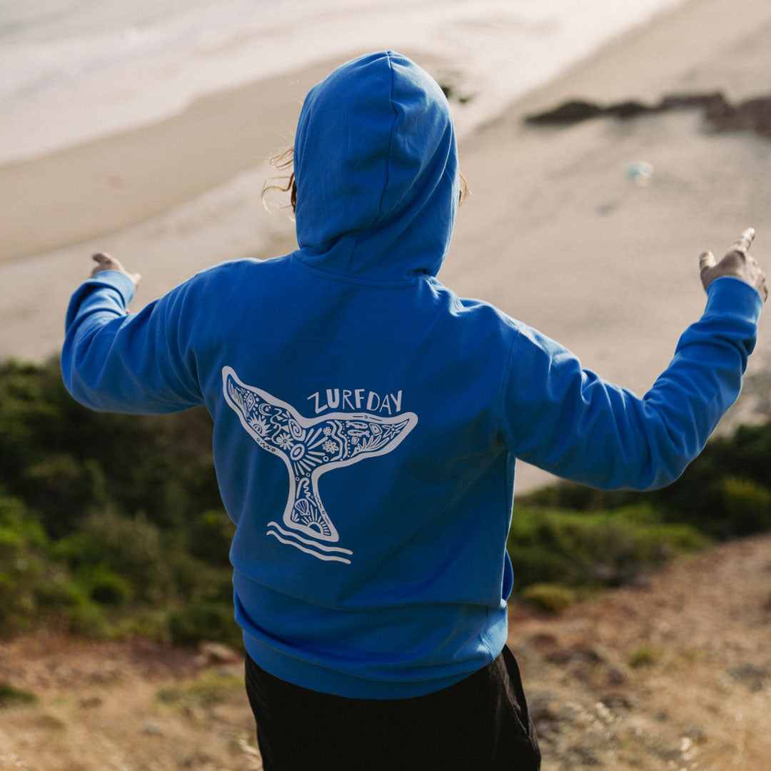 junger Surfer am Strand mit Zurfday Hoodie