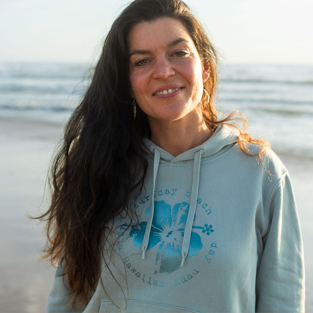 Portrait einer jungen Frau am Meer, sie trägt einen Zurfday Hoodie