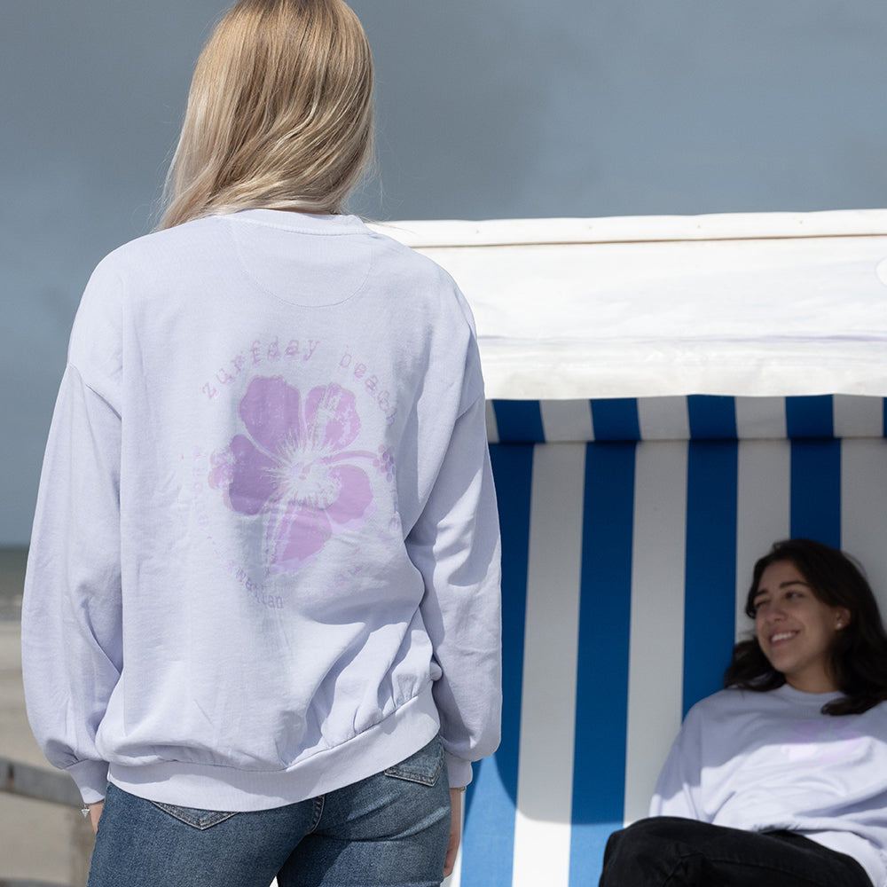 Junge Frau zeigt die Rückseite vom Hawaiian Luau Sweatshirt mit Print.