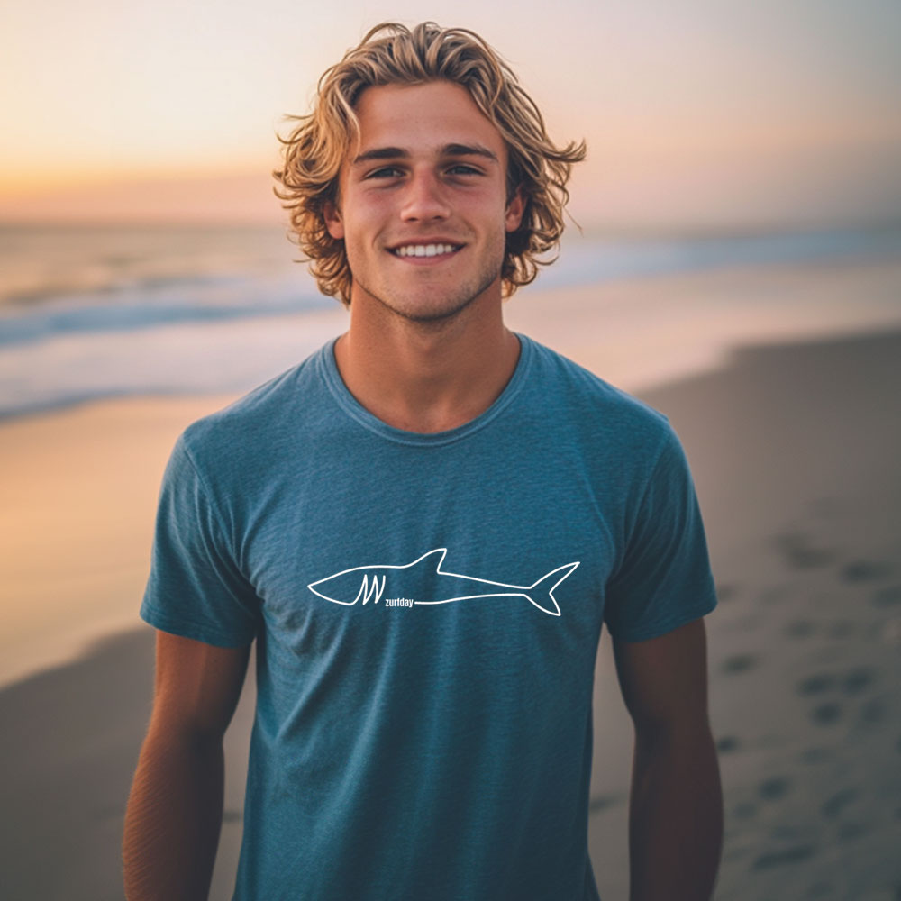Junger Surfer am Strand im T-Shirt mit Zurfday Hai Aufdruck
