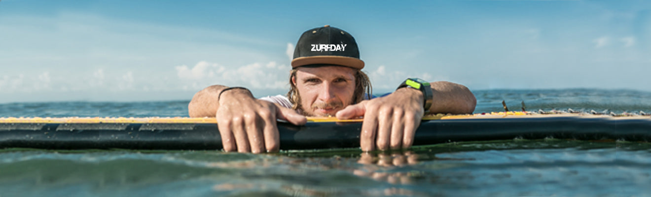 Surfer im Wasser trägt eine Basecap von Zurfday