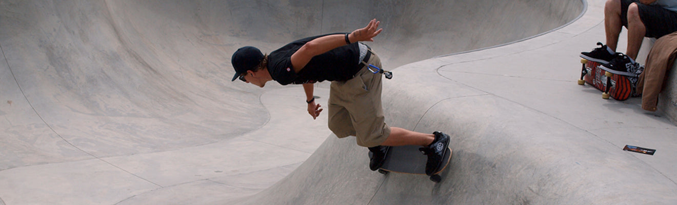 Junger Mann mit Skateboard in der Halfpipe, er trägt ein Zurfday T-Shirt