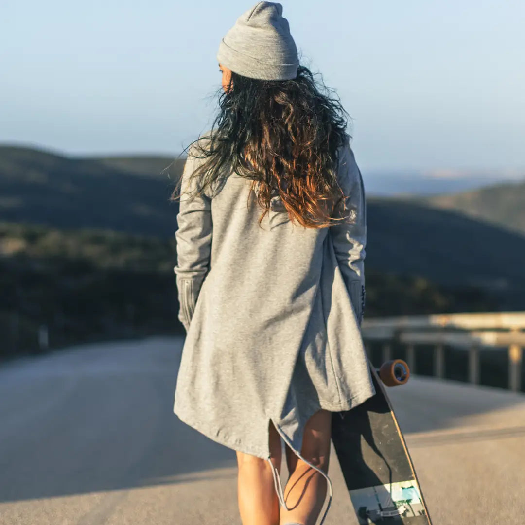 Junge Frau mit Skateboard von hinten fotografiert
