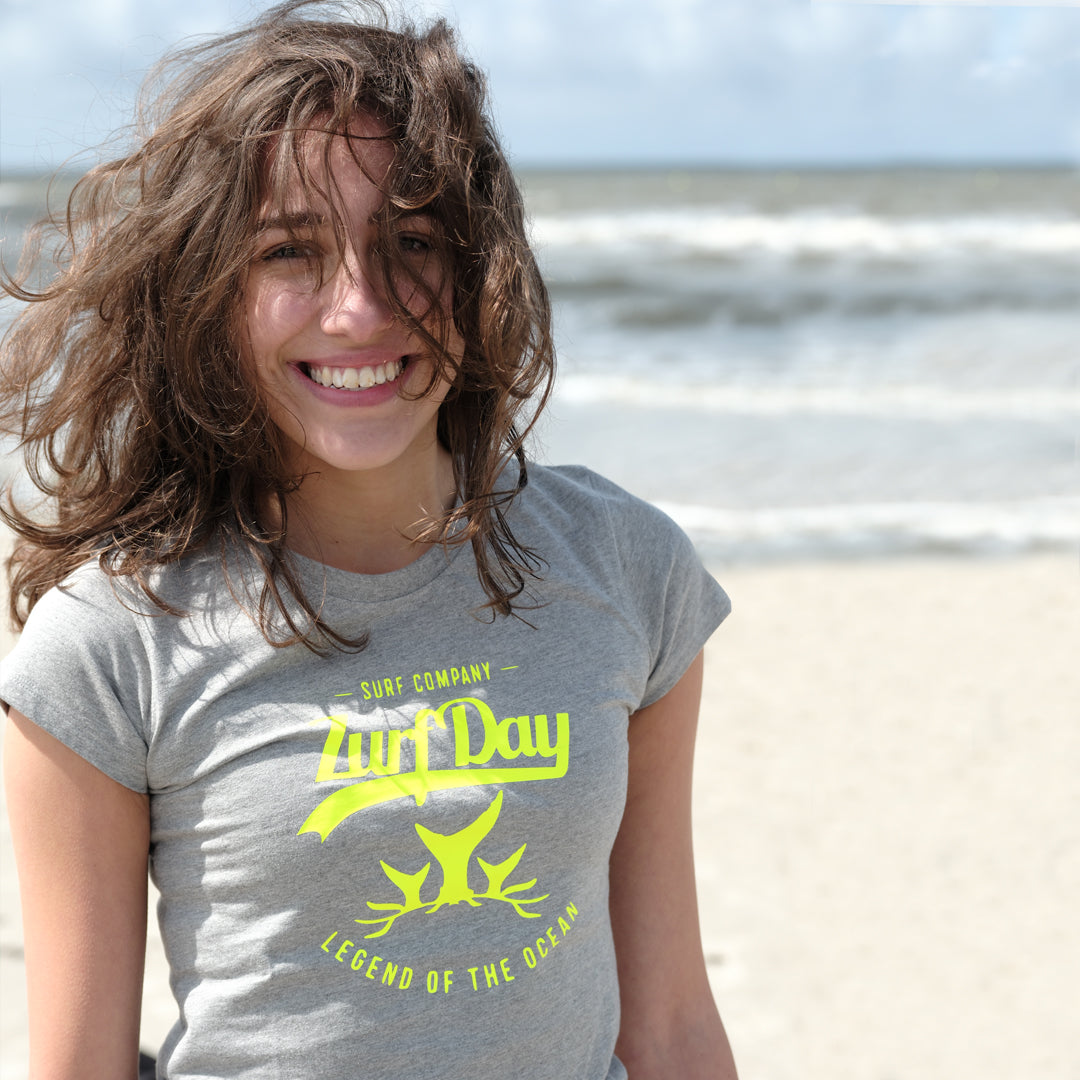 Frau am Strand trägt das graue SOS-T-Shirt von Zurfday.