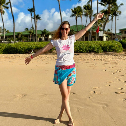 Eine junge Frau steht am Strand, sie lacht in die Kamera und trägt einen Zurfday Rock