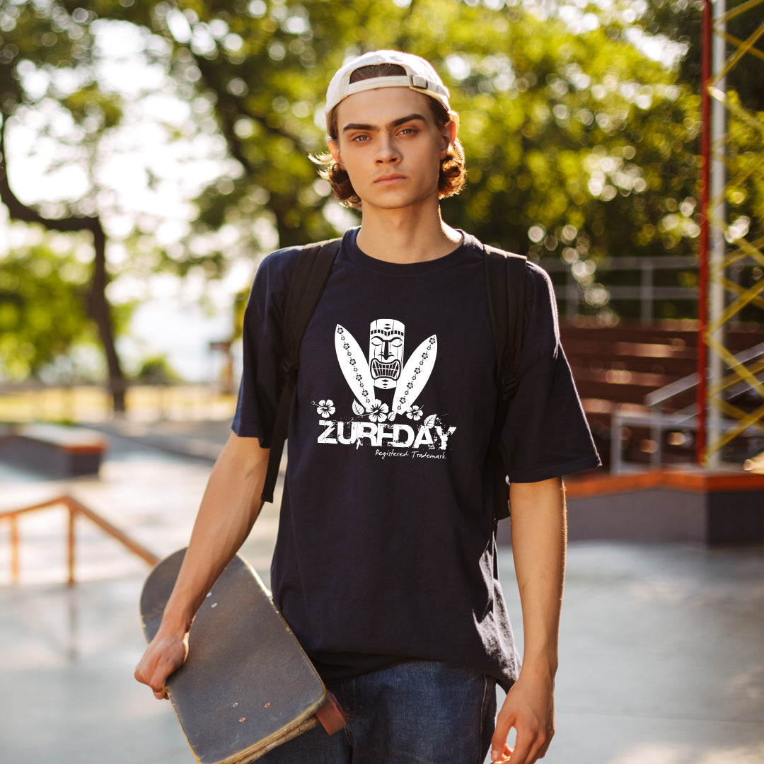 Junger Mann mit Capi und Skateboard unterm Arm trägt das Zurfday Aloha T-Shirt mit Druck in weiß.